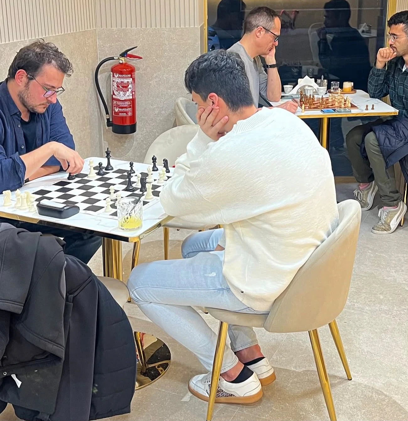 Visitantes disfrutando de una partida de ajedrez y café