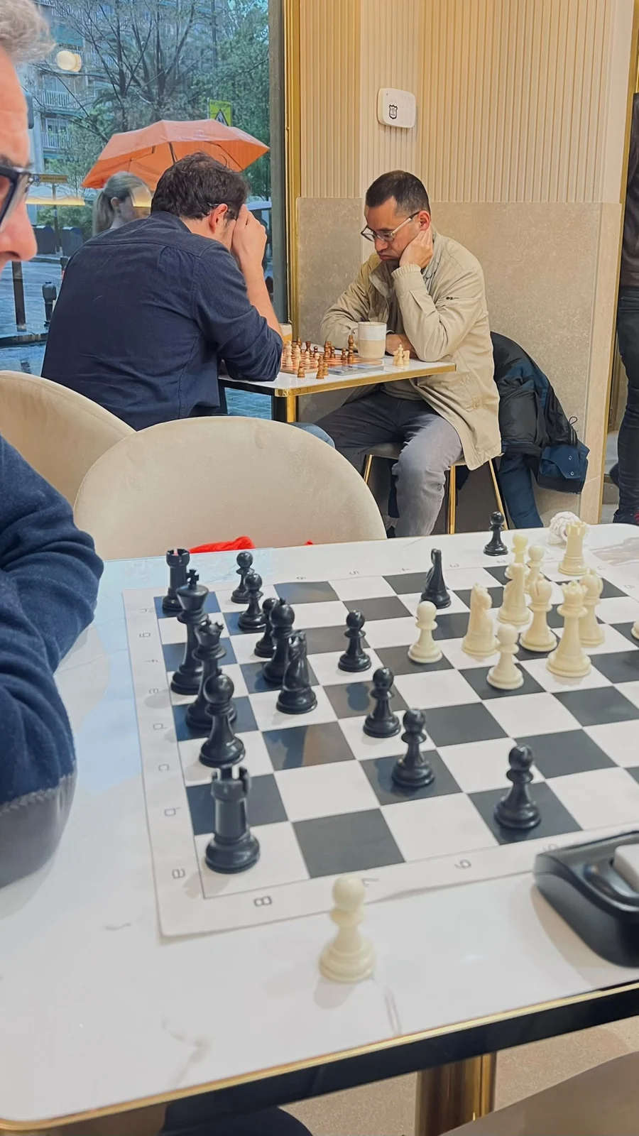 Visitantes disfrutando de una partida de ajedrez y café